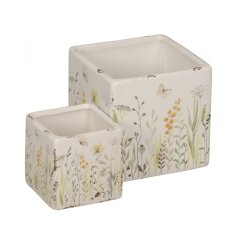 A set of 2 chunky stoneware square planters with a rustic finish. Each has a stunning wild meadow design