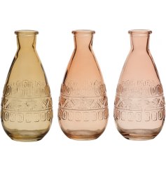 An assortment of 3 elegant vases in honey, peach and pink tones. Each has a stylish aztec pattern within the glass. 