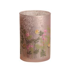 A tall speckled glass candle holder with a matte pink outer surface. Decorated with a pretty wild meadow decal.