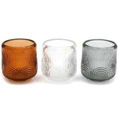 An assortment of 3 glass t-light holders, each with an embossed abstract design. 