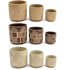 Abstract planters in natural colours, each with a raised abstract rainbow design. 