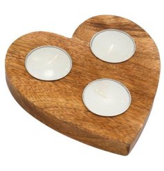 A rustic wooden heart shaped t-light holder with 3 candles. 