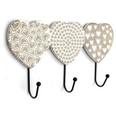 A row of 3 wooden heart shaped hooks, each with a unique carved heart pattern. Complete with a white washed finish