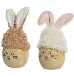 An assortment of 2 adorable wooden eggs with cute painted faces and bunny ear hats made from teddy fabric.