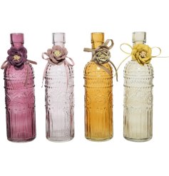 An assortment of 4 bohemian style glass bottles in jewel pink and cream colours. Complete with a pretty flower