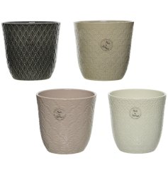 An assortment of 4 beautifully textured planters with floral and foliage themed patterns. The assortment includes grey, 