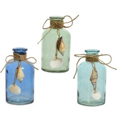 An assortment of 3 opaque glass bottles in a mix of blue and green colours. Complete with rustic bows and shells. 