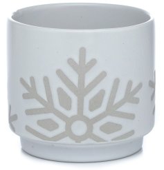 A chic stoneware plant pot with a white glaze and large snowflake relief. 