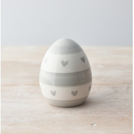 A chic egg ornament decorated with a grey heart and stripe pattern. 