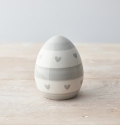 A chic egg ornament decorated with a grey heart and stripe pattern. 