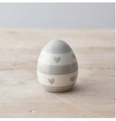 A chic egg shaped decoration with a heart and stripe painterly pattern.