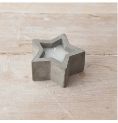 A rustic star shaped candle holder made from cement and filled with wax. 