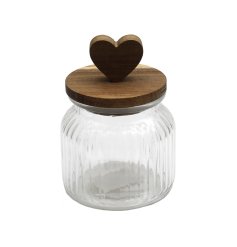 A stylish glass storage jar with ribbed container and a wooden lid with heart.