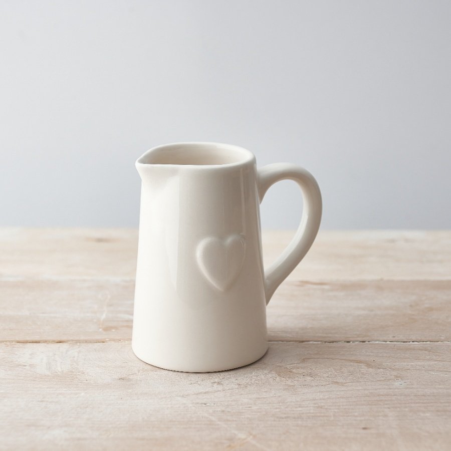 A classic white ceramic jug with an embossed heart detail. 