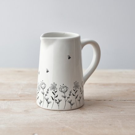 A charming wild flower design with bees adorns this chic white ceramic mug. 