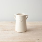 A white ceramic planter with eared design and embossed heart detail. 