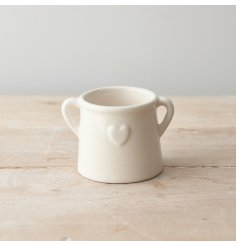 A chic ceramic planter with twin handle design and embossed heart detail. 