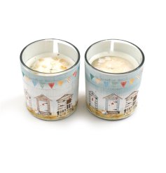 An assortment of 2 glass candles, each with a colourful seashore wrap featuring beach huts and bunting. 