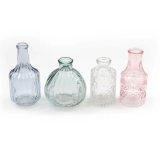 A set of 4 dainty glass bottles in varying designs. Each with cut glass patterns and a colour tint. 