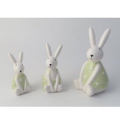 A charming sitting bunny ornament in white. Complete with charming green outfit with dainty pattern. 