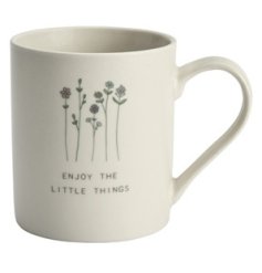A chic ceramic mug with wild flowers and a simple slogan reading 'ENJOY THE LITTLE THINGS'.