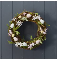 A pretty artificial wreath featuring pastel coloured speckled eggs and dainty artificial flowers.