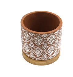 A large cement planter with white tile print repeat pattern and bamboo base.