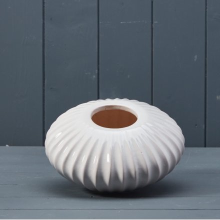 A white ceramic pot with ribbed texture feature.