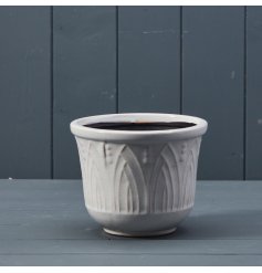 A white ceramic pot with a contrasting 3D pattern detailing.