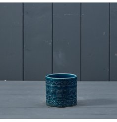 A ceramic pot in a beautiful blue finish and a repeat tribal style pattern.