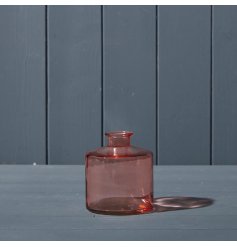 A beautiful rose pink short glass bottle.