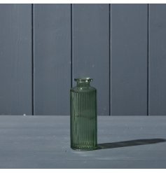 A beautiful vintage green glass bottle with ribbed texture design. 