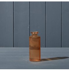 A beautiful ribbed glass bottle in a rich jewel tone cognac. 