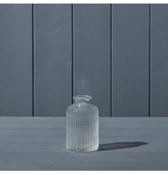 A clear glass bottle featuring a beautiful dimpled design. 