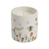 A charming ceramic candle pot, decorated with a colourful and cute bee and flower design