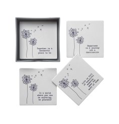 A set of 4 ceramic coasters, each featuring a beautiful dandelion design and a unique positivity slogan. 