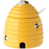 A ceramic pot shaped to resemble a beehive, comes with lid and spoon. 