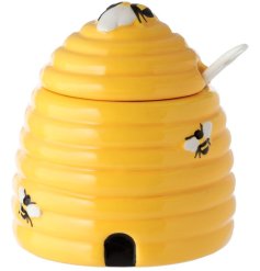 A ceramic pot shaped to resemble a beehive, comes with lid and spoon. 