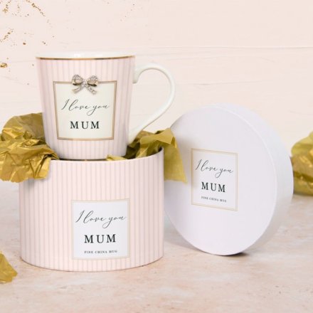 A pretty pink striped mug with gold accents and beautiful bow charm, with "I love you Mum" text. 