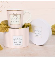 A beautiful pastel pink striped design mug featuring the text "fabulous sister" and finished with gold accents and bow. 