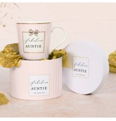A pretty pink mug with stripe pattern, gold detail and bow charm. With the text "fabulous auntie".