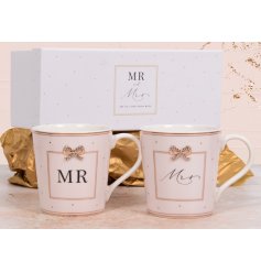 A charming set of Mr & Mrs mugs with pink polka dot pattern, bow charm and gold accents. 