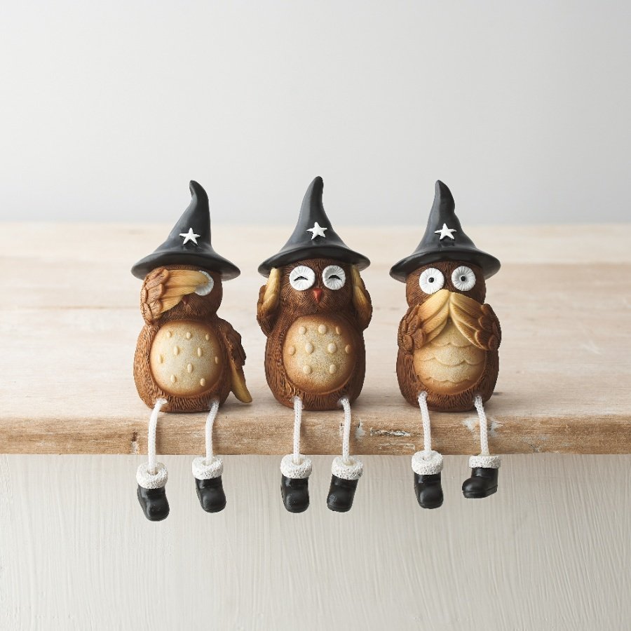 An assortment of 3 beautifully detailed wise owl ornaments, each with a black witches hat and dangling legs. 