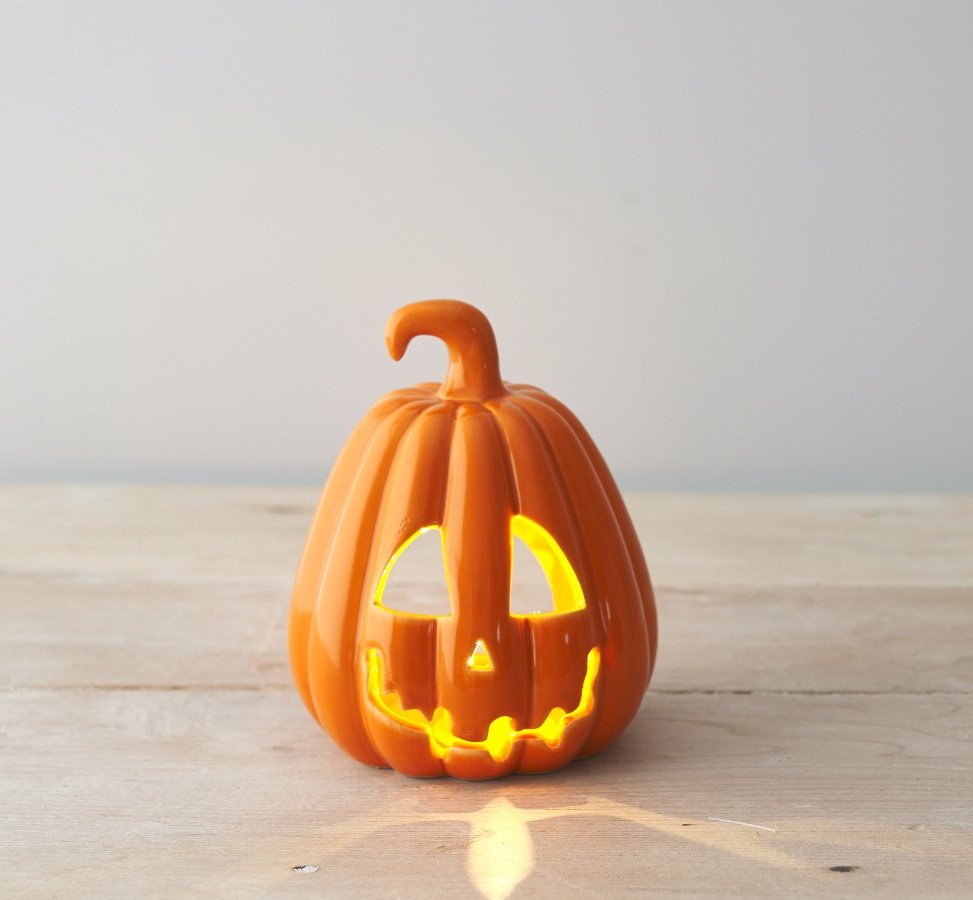 A chic ceramic pumpkin t-light holder with a rich orange glaze and spooky carved face. 