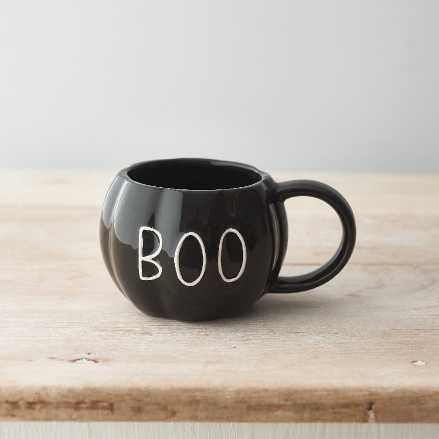 A chic pumpkin shaped mug with a black glossy glaze and an embossed BOO slogan. 