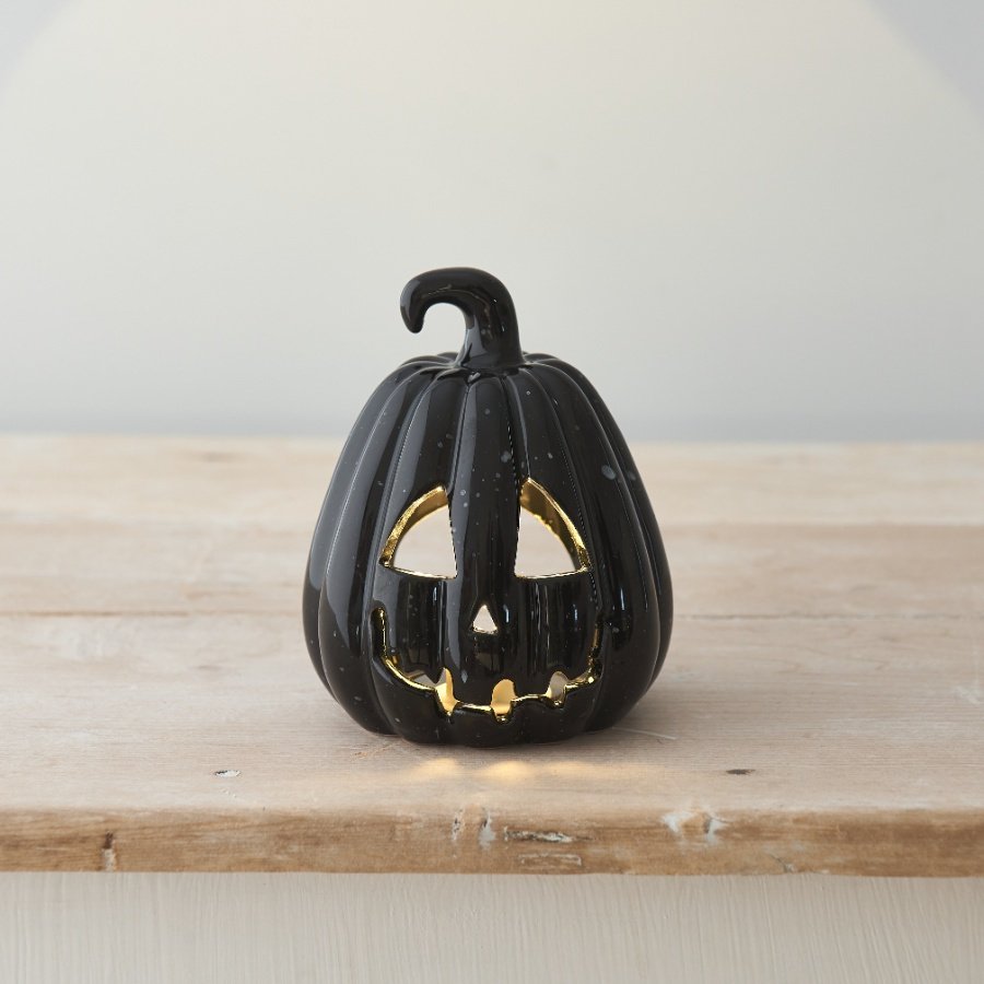 Light up your home this season with this chic black ceramic t-light holder, complete with a carved spooky face and stalk