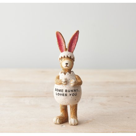 A cute resin rabbit stood inside a egg with text on the front. 