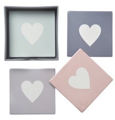 A set of 4 pretty pastel coasters, each with a contrasting white heart motif. 