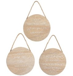 A wooden round hanging sign with printed sentiment on the front and patterned edge detail. 
