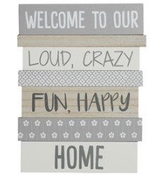A multi panel wooden sign with "welcome to our loud, crazy, fun happy home" text and pretty patterns including daisies. 